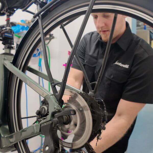 Scooteretti service technician performing maintenance on an electric bike in Ottawa