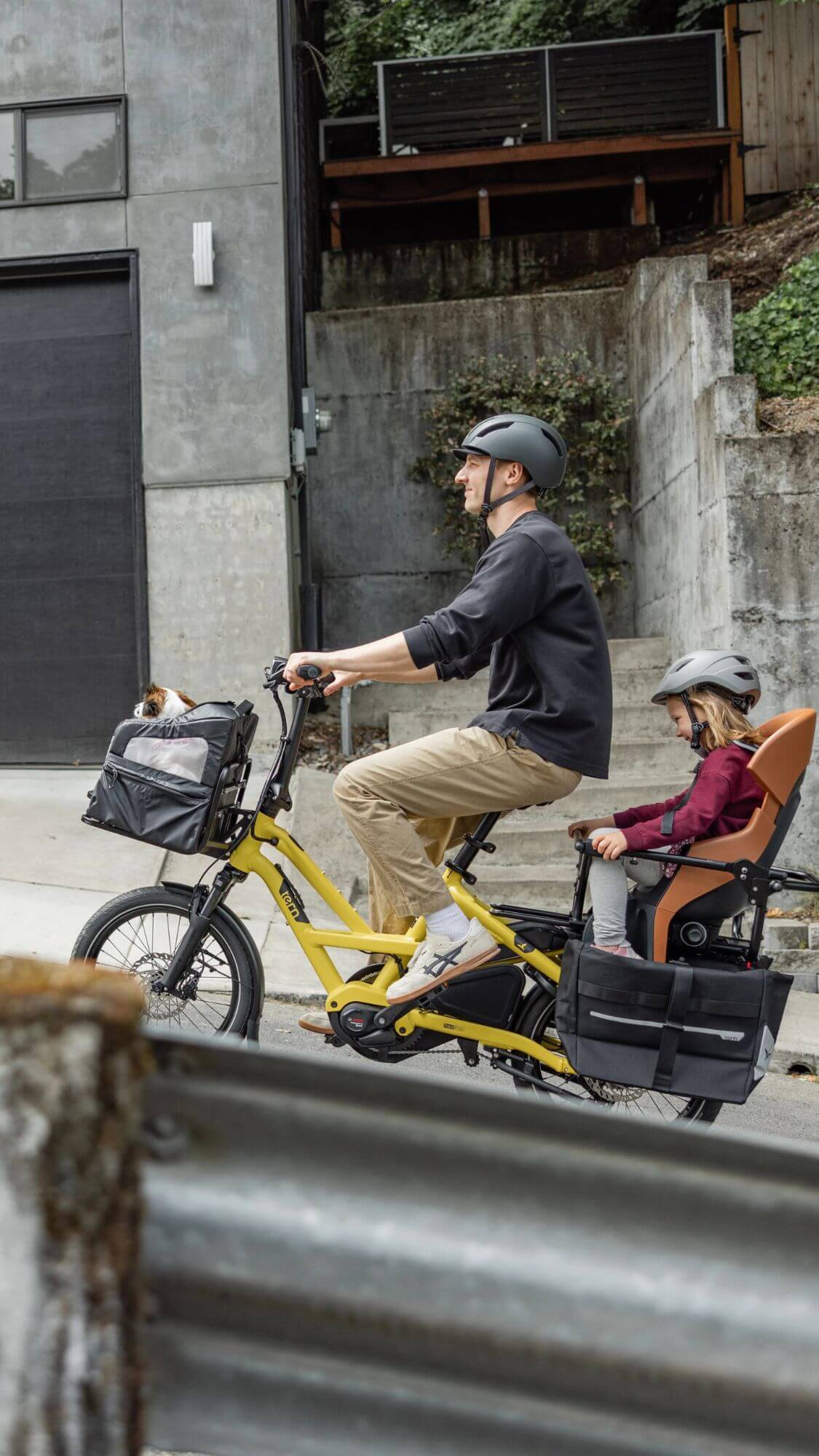 Man riding a Tern HSD P5i electric cargo bike with his child up a hill